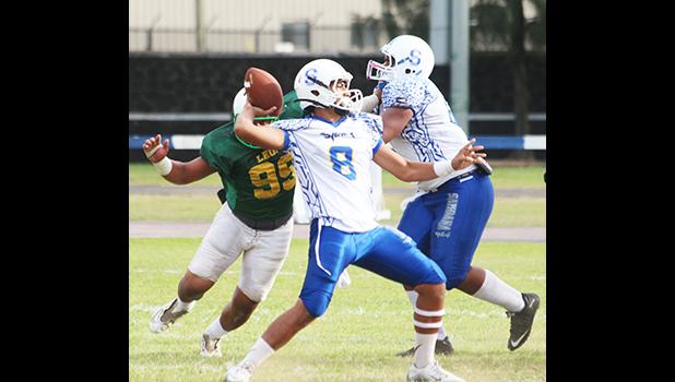 Anthony Feala of the Sharks, flexing to pass to Elliot Lelei for another touchdown conversion in the second quarter of their varsity game against the Lions last Saturday afternoon. Feala led the Sharks in a dominating 34-8 victory.  [photo: TG]