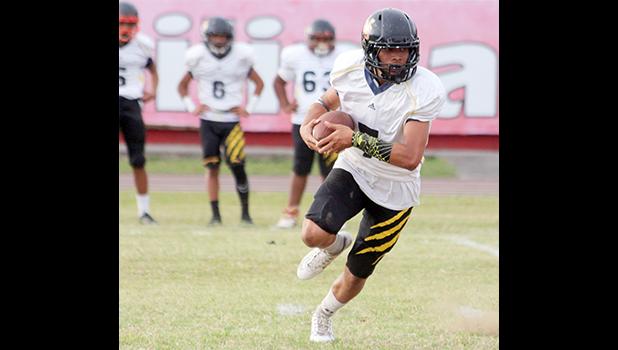 Nu’uuli Wildcats quarterback, Daniel Maea scrambling out with the ball and opting to keep it on a play-action pass play against the Vikings last Friday evening at the Veterans Memorial Stadium. [photo: TG]