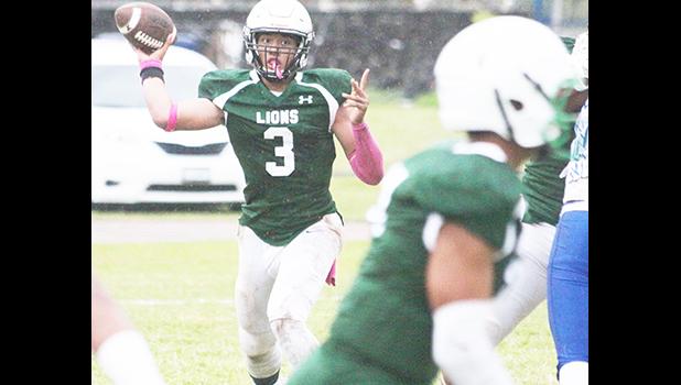 Iverson Ta’ase of the Lions locking on to Ali’itoa Langkilde and attempting a pass during the opening half of their varsity game against Samoana last Thursday evening. The Sharks won 14-0. [photo: TG]