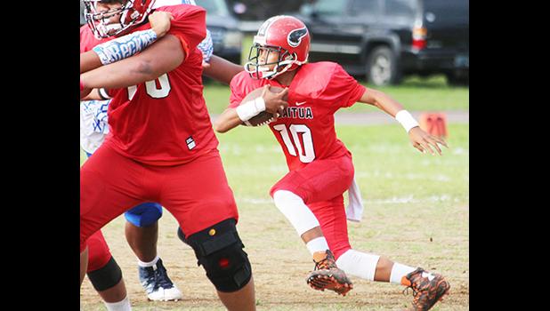 Fa’asili Al-Shadai tucking the football and opting to run with it for the Vikings first and only touchdown during a match against the Sharks last Thursday evening. Samoana defeated the Vikings 20-6. [photo: TG]