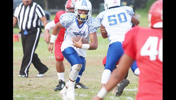  The No.1 ranked quarterback in the ASHSAA JV Division, Jr. Tanielu storming through midfield with a tuck and run play after not finding an open receiver, during the first half of their JV match up against the Vikings last Thursday evening. Tanielu led the Sharks to a ‘Back-2-Back’ Championship title after beating Faga’itua 20-6. [photo: TG]