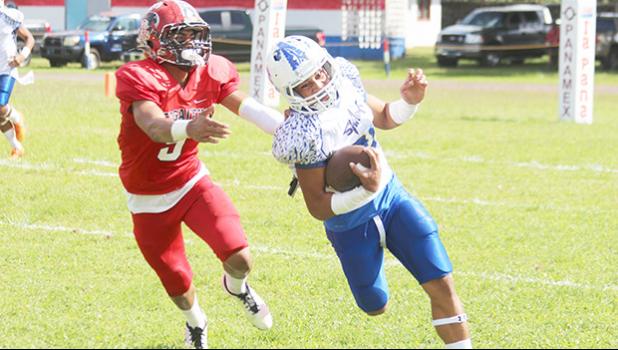 Paul Fano — who helped Samoana’s JV team to a ‘Back-2-Back’ Championship title this year — was moved up to the varsity level last Saturday, and carried the load for the Sharks as the Blue Empire opted to give Moses Michael Samia a break, and easing off Lewis Malala Jr., two of their best ball carriers this year. Fano is pictured trying to evade a tackle by Vikings senior safety, Aroni Taua’a. [photo: TG]