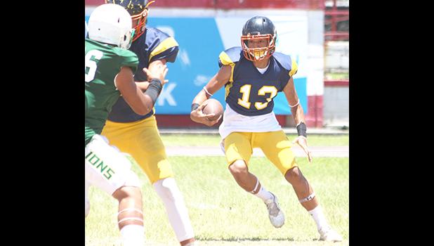 Wildcats quarterback, Diamond Vea scrambling with the football, after failing to find an open receiver for a pass during the second quarter of their varsity match up against the Lions. The Wildcats were shut out in 32- 0 loss.  [photo: TG]
