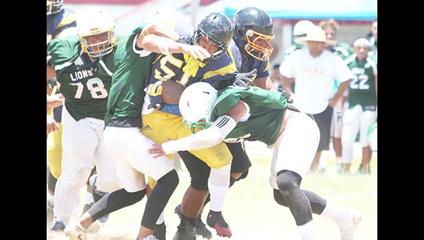 Leone Lions' defensive unit devouring Dennis Enoka of the Wildcats at midfield, during the opening quarter of their final game of the season. Leone shut out the Wildcats 32-0. [photo: TG]