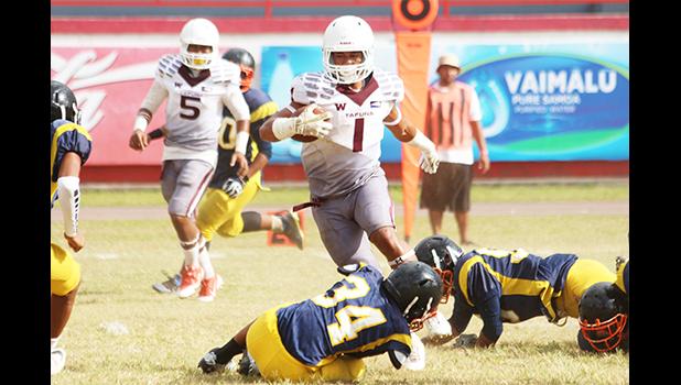 Panapa Filoiali’i of the Warriors dancing through falling Wildcat defenders as he skipped his way to the end zone on this play – his fourth touchdown run of the first half. Filoiali'i led the Warriors in a 54-6 victory against the Wildcats last Saturday morning, giving Tafuna its second win of the regular season.  [photo: TG]