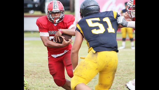 Faga'itua's Advent Migi carrying the ball and staring down Dennis Enoka from Nu’uuli before a collision at the line of scrimmage during the second half of their Varsity match up this past Saturday morning at the Veterans Memorial Stadium. Migi helped the Vikings win 53-0. [photo: TG]