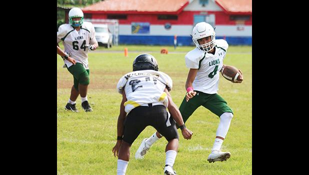 Leone Lions quarterback, Oakland Salave’a running downfield with a quarterback keeper for a huge gain for the Lions during the opening half of their Junior Varsity game against the Wildcats this past Saturday morning – the match was scoreless.  [photo: TG]