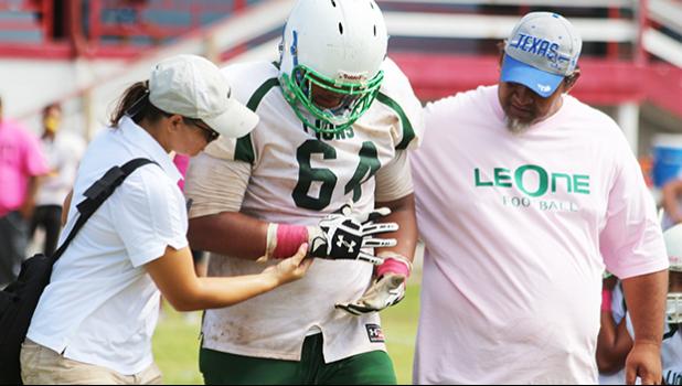 An injured Leone Lion is walked off the field while being checked out by ASHSAA ATC Florence Wasko during the first half of a JV game last Saturday morning at the Veterans Memorial Stadium.  [photo: TG]