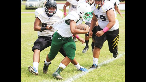 A Leone Lions tailback being apprehended and about to be tackled for a loss by the Wildcats defense during the second half of play of their Junior Varsity match up where both teams were scoreless last Saturday morning. [photo: TG]
