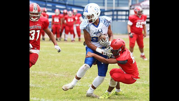 Avery Seumanutafa dragging a defender and trying to brace for impact from another defender after securing a catch in the first half of their JV game against the Vikings last Saturday morning – Seumanutafa helped the Sharks in their 32 - 6 victory.  [photo: TG]