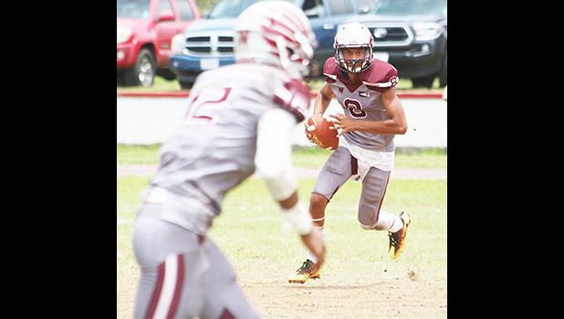 Francisco Mauigoa of Tafuna rolling out with the ball, and locking on to his receiver Pa’apa’a Mauigoa, during the first quarter of their JV match up against the Vikings last Saturday morning. The Warriors won 24-0.  [photo: TG]