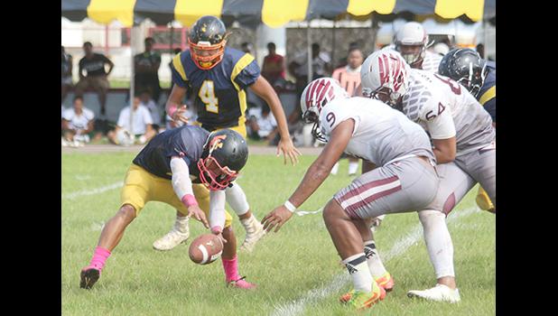 Iosefa Mauga trying to recover a fumbled pitch from Ziggy Faletoi in the backfield – as Elton Titania and the Warriors defensive unit arrive on the scene, trying to recover the fumble, in the second quarter of a varsity match last Saturday morning. Tafuna defeated the Wildcats 38-12.  [photo: TG]