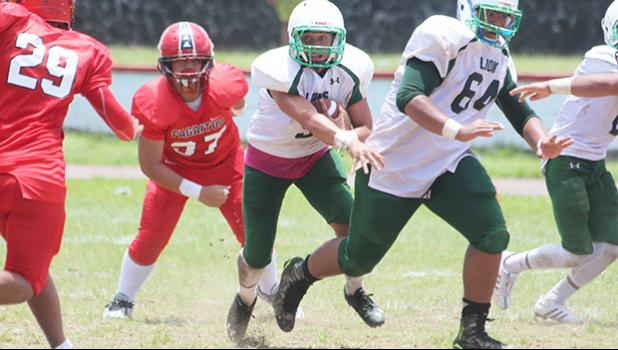 Ron Fuala’au of Leone slipping away from a tackle by Tau Lopesi, as he looks downfield for more open gaps for a huge Leone gain. Fuala’au scored two touchdowns in their 26-14 win against the Vikings. [photo: TG]