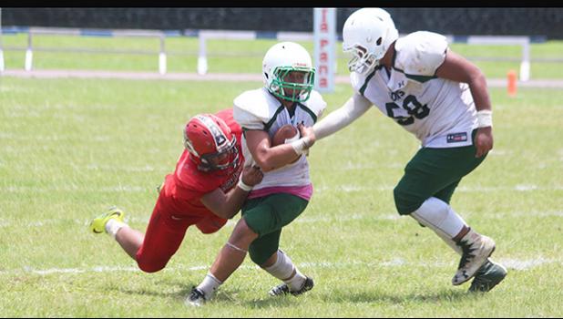 Ron Fuala’au of the Lions immediately stopped in the backfield by Jake Umu of the Vikings during the second half of their junior varsity match up last Saturday morning. Fuala’au helped the Lions to a 26-14 win, their first victory of the season. [photo: TG]