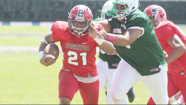 Pitonu’u Ah Sue of Faga’itua storming down the sidelines, trying to evade a tackle from a Leone defender during the opening half of a varsity match up last Saturday afternoon. Ah Sue helped the Vikings in a 32-26 comeback victory.  [photo: TG]