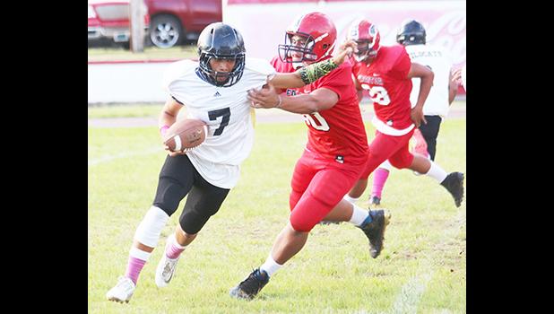 Nathaniel Maea of Nu’uuli trying to escape a sack in the backfield by a Viking defender during the third quarter of their JV match up last Thursday evening where Nu’uuli collected their first win of the season after defeating the Vikings 14-6.  [photo: TG]