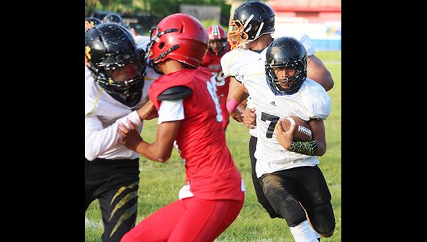 Nathaniel Maea of Nu’uuli with the quarterback keep trying to read his blockers downfield as he gained huge yardage for Nu’uuli on this one. Maea helped the JV Wildcats to their first victory of the season, a 14-6 win over Faga’itua.  [photo: TG]
