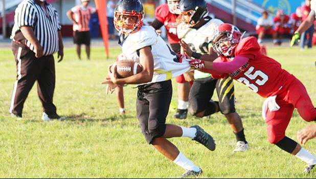 Isileli of the Wildcats at midfield trying to evade a touchdown saving tackle by O’Neil of the Vikings during the opening half of their JV game last Thursday evening. Isileli helped the Wildcats to their first win of the season after beating Faga’itua 14-6. [photo: TG]