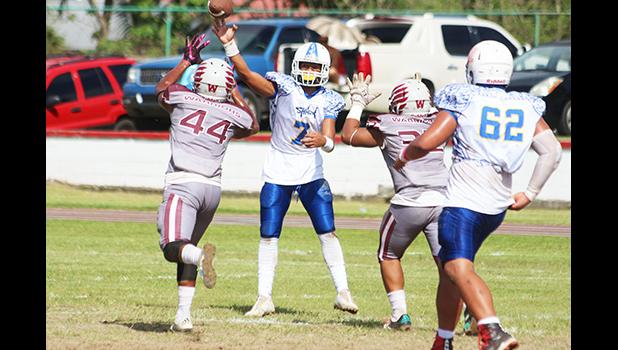 Jr. Tanielu releasing a screen pass just seconds before getting sandwiched by two Tafuna defenders, during their JV match up last Saturday morning. Tanielu led the Sharks in a 8-6 victory over the Warriors.  [photo: TG]