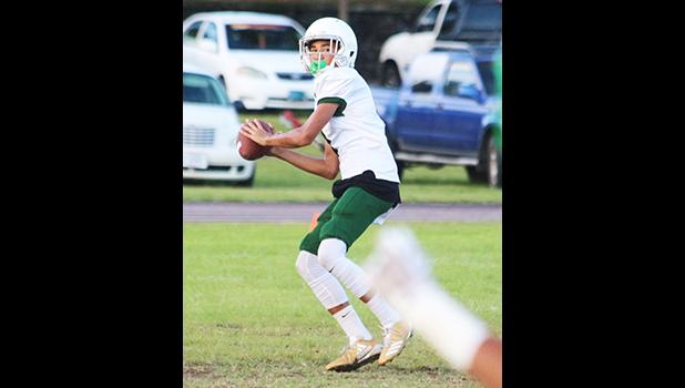 Leone Lions quarterback, Oakland Salave’a locking on to a receiver for a long pass from midfield, during the opening quarter of their JV match up against the Warriors last Thursday evening, where Salave’a led the Lions to their third victory of the season, a 16-6 win. [photo: TG]