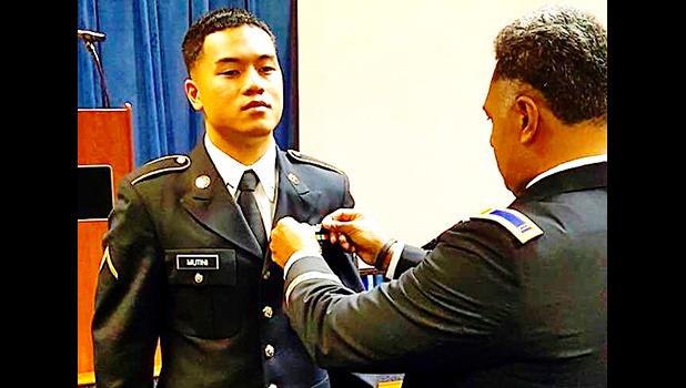 PV2 Nikolao II Chacko Mutini having his wings pinned on by his brother John.