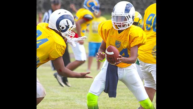 Rams quarterback Taiese Saofaigaalii is about to send Miraculous Naiuli up the middle with the hand off during the second quarter of an AYFS semi-final match last Saturday. [photo: TG]