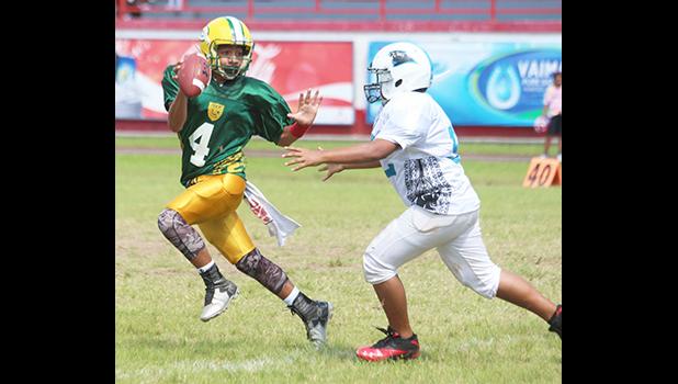 AYFS Packers quarterback Alfred Maiava trying to escape the rush from a Panthers defender early in the opening quarter of their match up last Saturday morning. Maiava led the Packers to a 32 - 6 victory, their second win of the season.  [photo: TG]