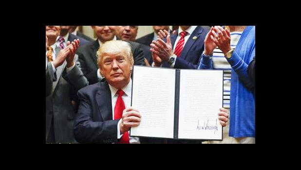  In this April 28, 2017, file photo, President Donald Trump holds up a signed Executive Order in the Roosevelt Room of the White House in Washington directing the Interior Department to begin review of restrictive drilling policies for the outer-continental shelf. The AP reported on May 26, 2017, that a story shared by the St. George Gazette website claiming Trump signed an executive order allowing the hunting of bald eagles is a hoax. (AP Photo/Pablo Martinez)