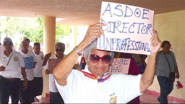 Man holds sign saying ASDOE director is unprofessional
