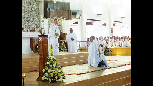 Bishop-elect Reverend Father Etuale kneels