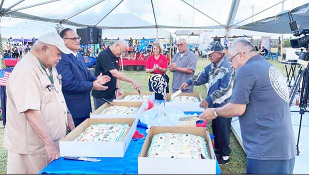 Veterns cutting the cake at a Pre-Veterans Day block party