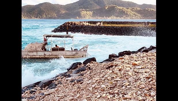 A boat in rough surf at Aunuu
