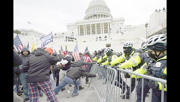 Trump supporters try to break through a police barrier, Wednesday, Jan. 6, 2021, at the Capitol in Washington. As Congress prepares to affirm President-elect Joe Biden's victory, thousands of people have gathered to show their support for President Donald Trump and his claims of election fraud. (AP Photo/Julio Cortez) Trump supporters try to break through a police barrie