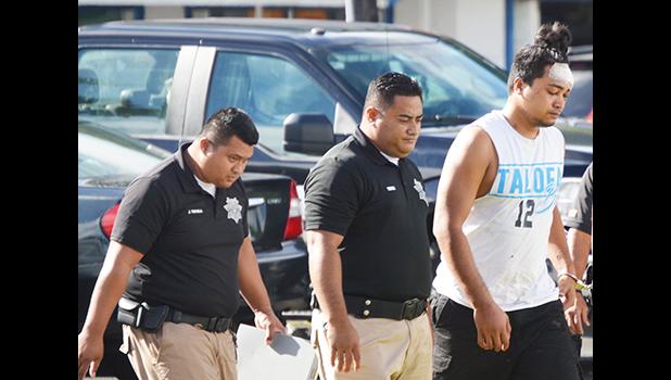 Chanel Lafua handcuffed with police guards