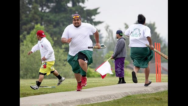 John Reno Sagaga, second from left, passes teammate Onosai Sanerivi after Sagaga hit the ball during a kirikiti game at Jefferson Park. (Ellen M. Banner / The Seattle Times) John Reno Sagaga, second from left, passes teammate Onosai Sanerivi