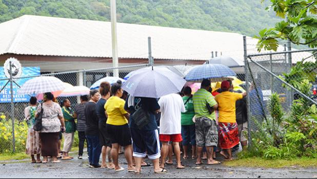 Crowd with umbrellas waiting at DMWR gate