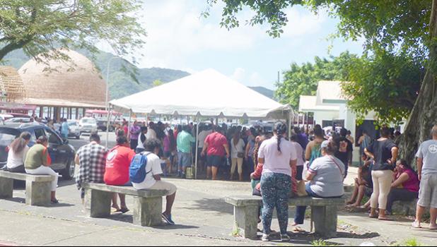 A crowd gathered at Social Service office under the tents with no social distancing