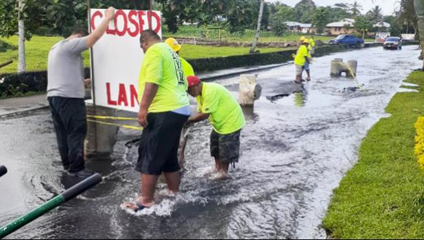 DPW crew installing lane closed sign where Fagaima road is flooded