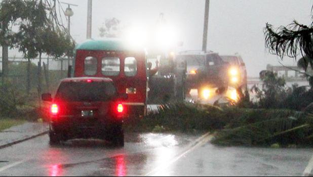 Emergency crews rushed to the scene a large downws tree in Fagaalu around 7a.m. Friday to clear the road as well as move an aiga bus, which was hit on the front section when the tree fell in the midst of strong gust winds from Tropical Storm Gati. No one was injured.  [photo: Fili Sagapolutele]