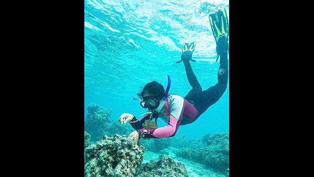 Molina swimming over a reef in snorkle gear