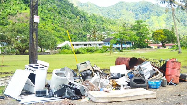  various types of garbage being dumped under and near the pole