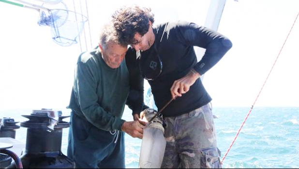  Captain Charles Moore (left) and a crew member collect plastic from the South Pacific gyre. [Photo: Supplied/ Algalita Marine Research]