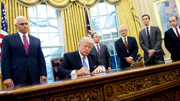  Donald Trump, seated, signed, three executive orders on Monday, including one banning any US-funded organisations from speaking about abortion. [Photo: AFP via RNZI] 