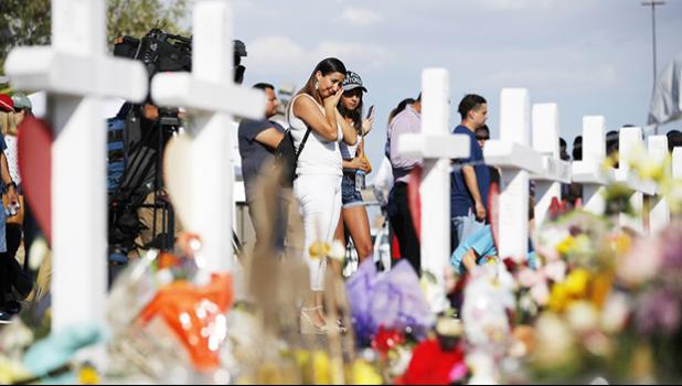 People visit a makeshift memorial, Monday, Aug. 5, 2019, at the site of a mass shooting at a shopping complex, in El Paso, Texas. (AP Photo/John Locher) People visit a makeshift memorial in El Paso, Texas