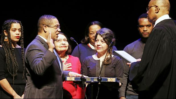 In this Monday, Jan. 7, 2019 file photo, former U.S. Rep. Keith Ellison, second from left, surrounded by family members, places his hand on the Koran as U.S. District Judge Michael Davis administers the oath of office for the new Minnesota attorney general during ceremonies in St. Paul, Minn. On Friday, March 8, 2018, The Associated Press has found that stories circulating on the internet that Ellison and U.S. Rep. Ilhan Omar, D-Minn., urged people to vote twice in same election, are untrue. (AP Photo/Jim Mone) former U.S. Rep. Keith Ellison