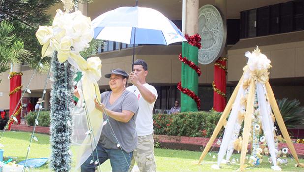Two ASG employees hang Christmas lights at the EOB