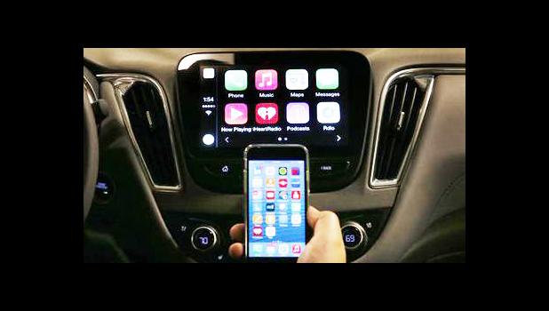  In this May 26, 2015 file photo, an iPhone is connected to a 2016 Chevrolet Malibu equipped with Apple CarPlay apps, displayed on the car's MyLink screen, top, during a demonstration in Detroit. The rapidly evolving in-car infotainment and navigation systems can be bewildering for all but the most tech-savvy car buyers. The average vehicle on U.S. roads is 11 years old; that means many people last went car shopping before iPhones were invented. (AP Photo/Paul Sancya)