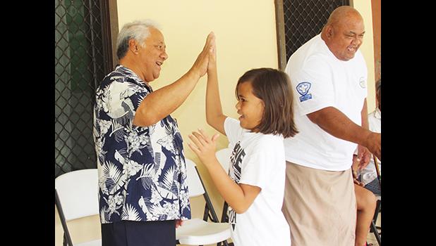 FFAS president, Sen. Faiivae Iuli Alex Godinet, high fives a player on