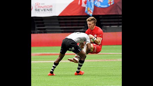 Canada’s Luke McCloskey is pummeled by Fiji’s Aminiasi Tuimaba