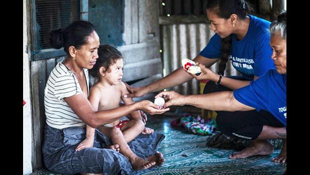Lead coordinator Susitina Lene helps to administer treatment to a family in Leauvaa